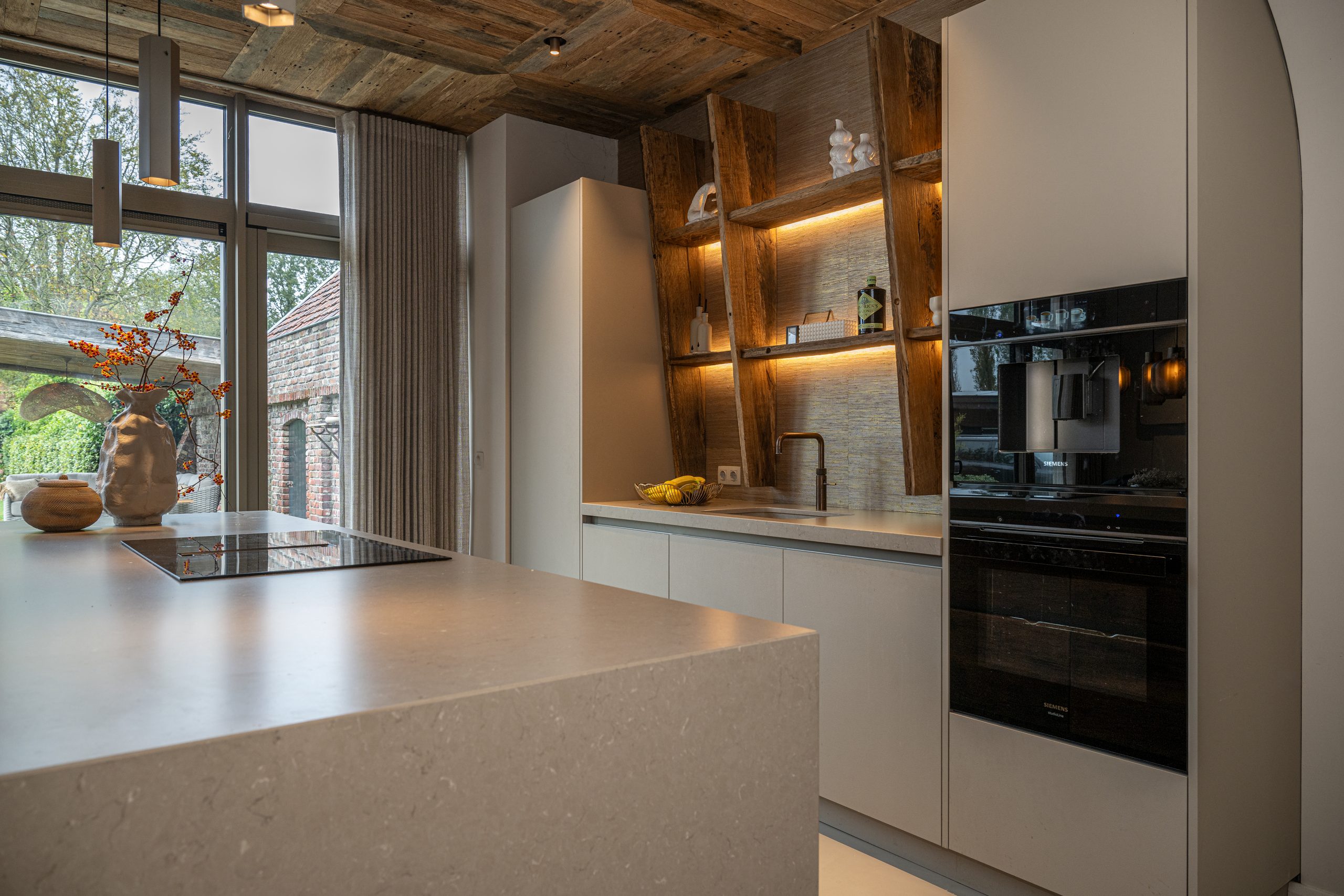 Moderne landelijke keuken met wandplank van oud eiken hout en sfeervolle verlichting