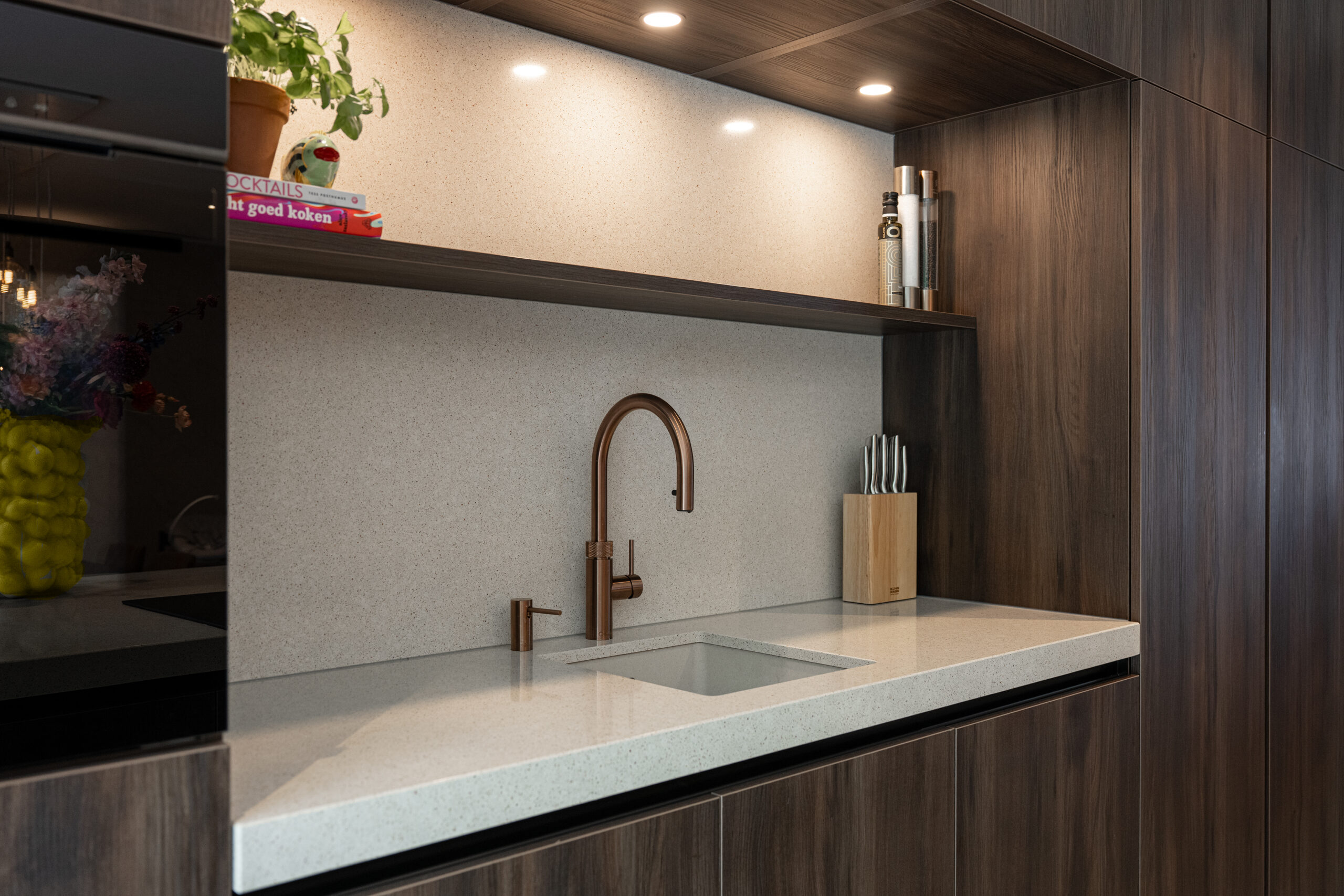 Moderne keuken geplaatst tussen hoge kasten voor strakke indeling