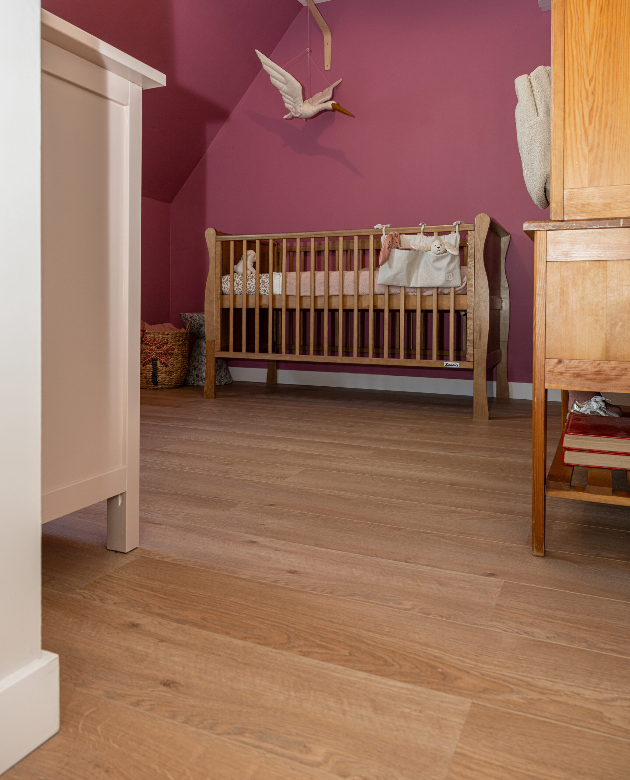 Babykamer met laminaatvloer in warme houtlook