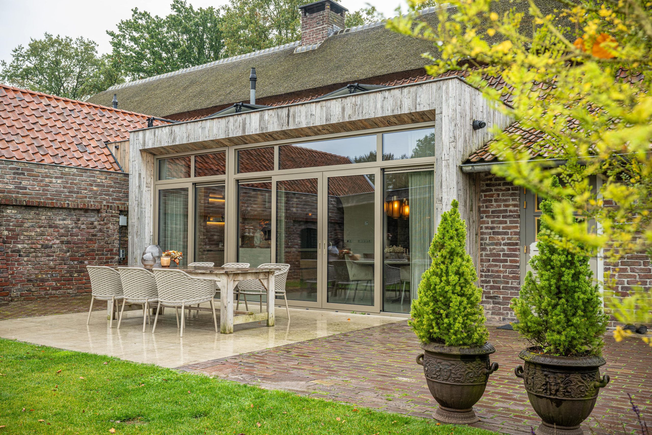 Landelijke overkapping of aanbouw, geïntegreerd met woning en tuin