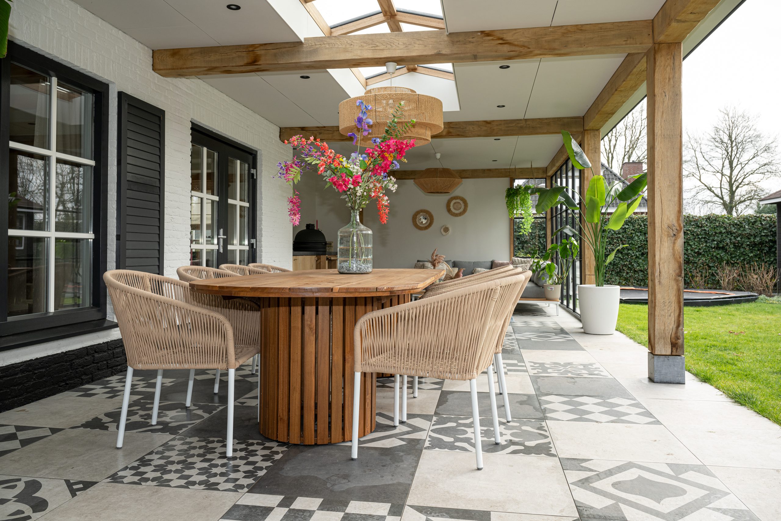 Overkapping met loungehoek en eettafel voor comfortabel buitenleven