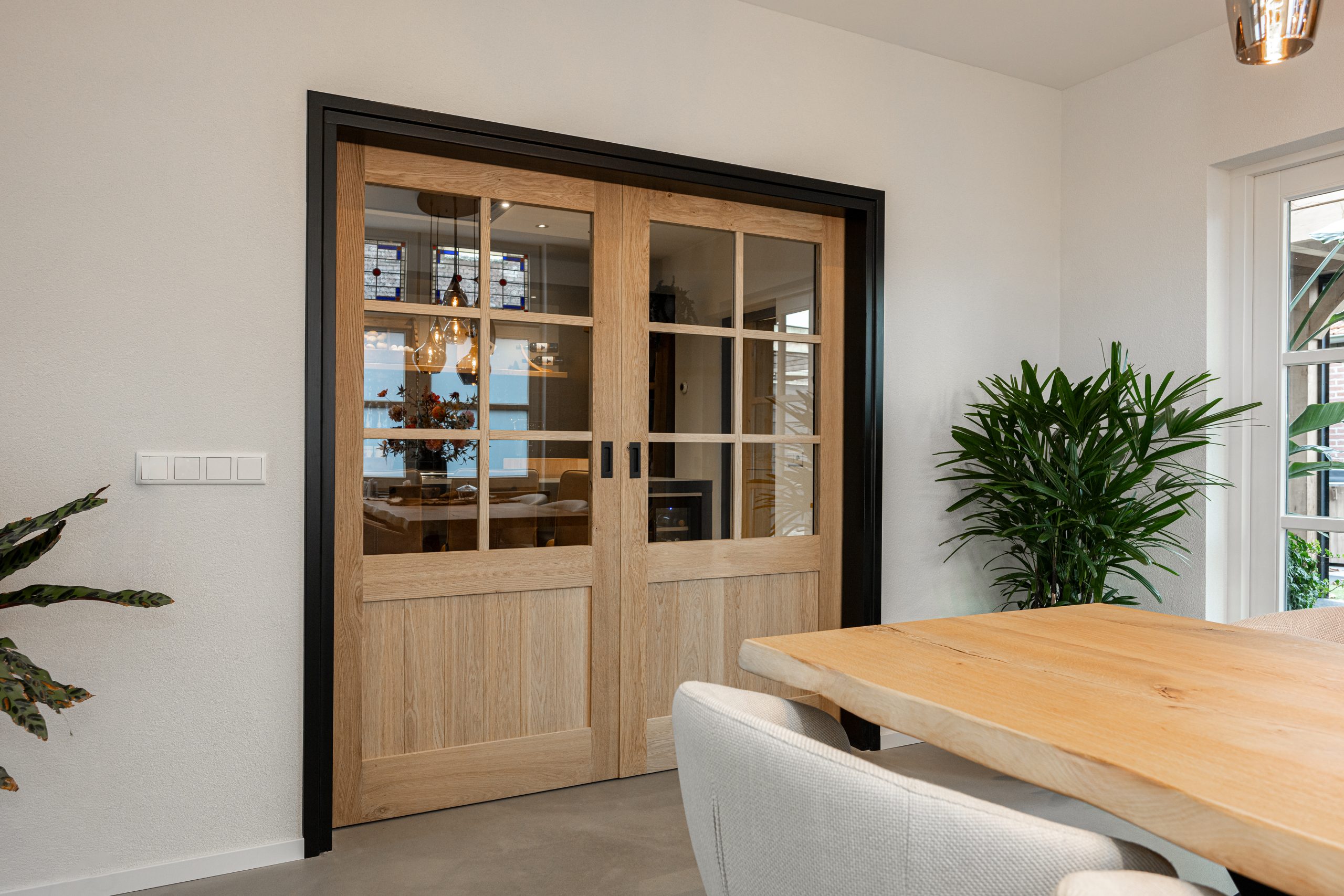 Dubbele schuifdeuren tussen keuken en woonkamer in landelijk interieur