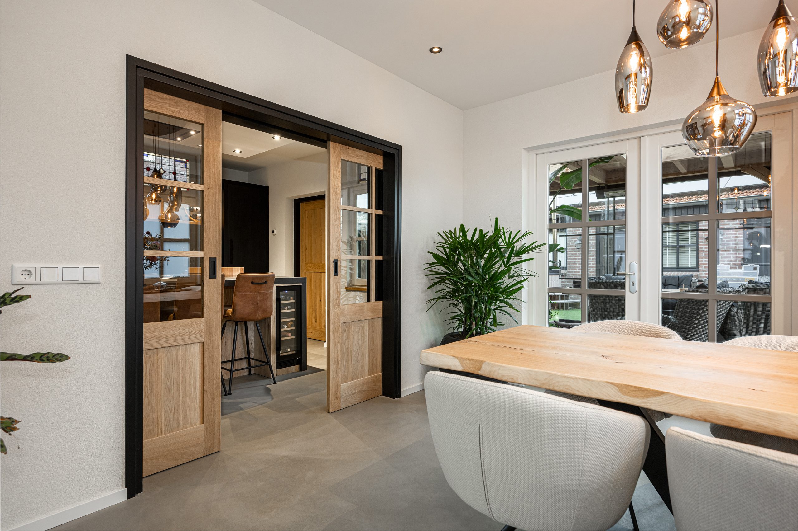 Eiken dubbele schuifdeuren die keuken verbinden met woonkamer