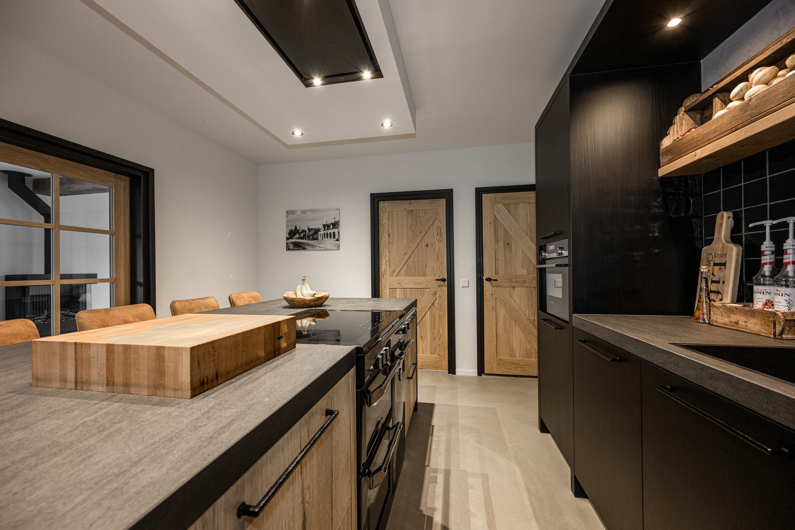 Massief eiken binnendeur naast zwarte keukenwand