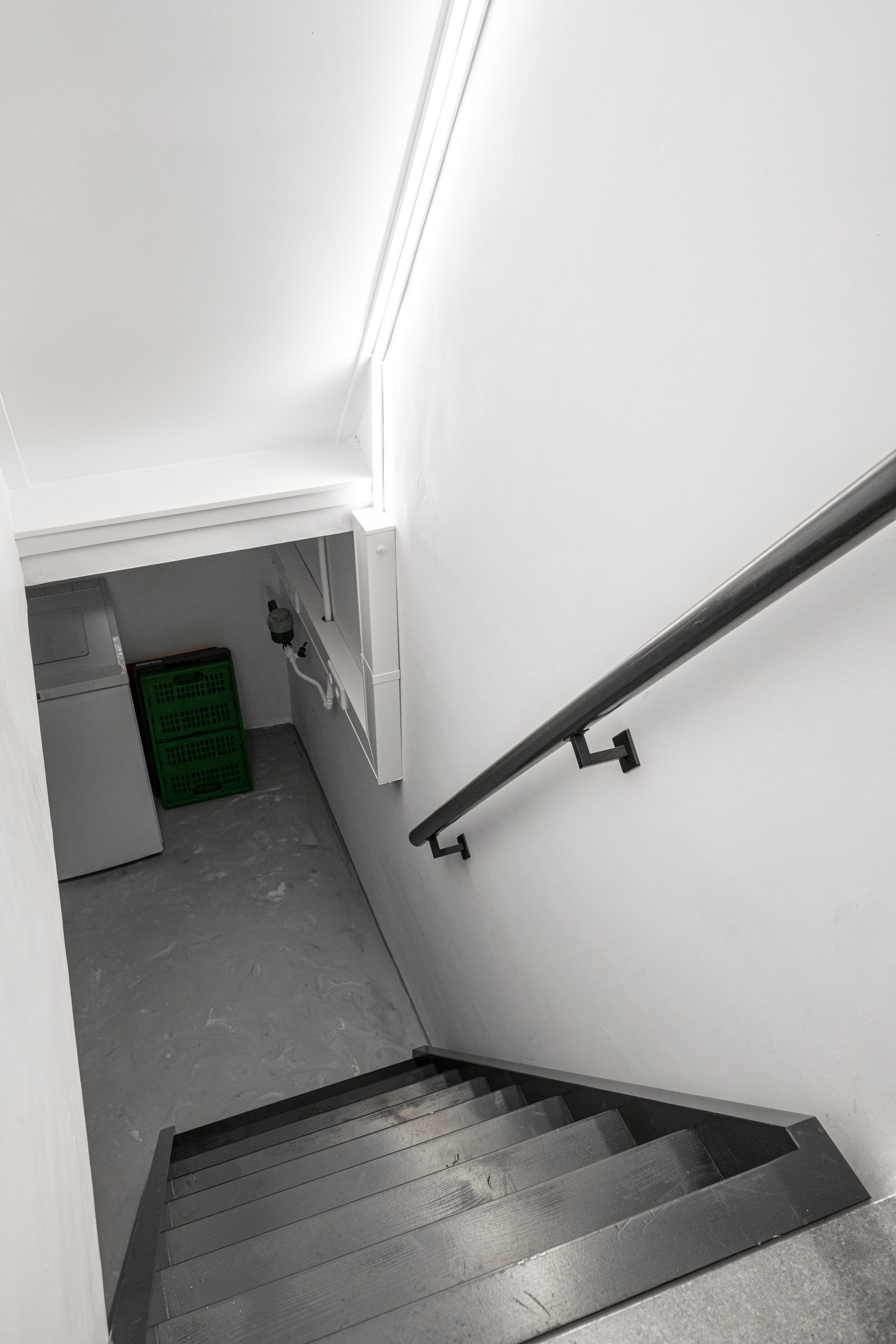 Zwarte houten keldertrap met zwarte leuning