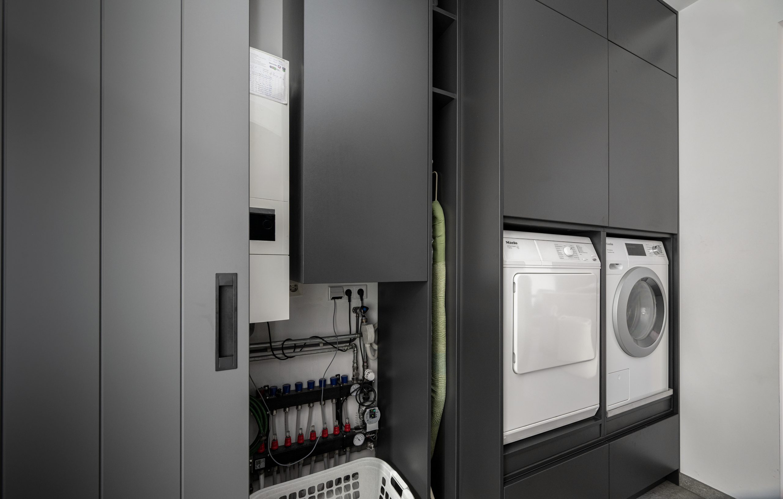 Zwarte opbergkast voor wasmachine in berging, naast de CV-ruimte voor optimaal gebruik van de ruimte