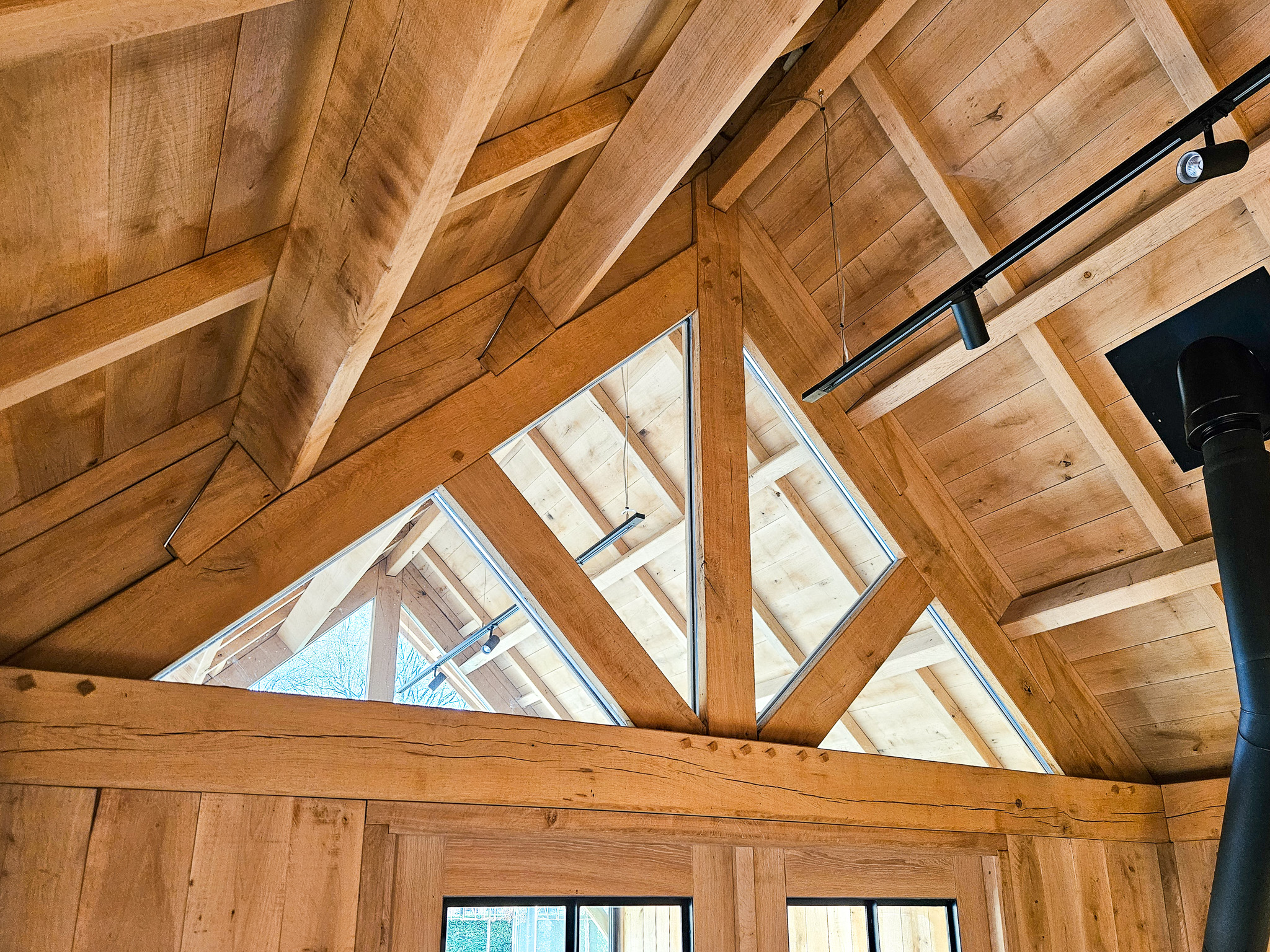 Close-up van de zware eikenhouten balkenconstructie van het dak in een luxe tuinhuis.