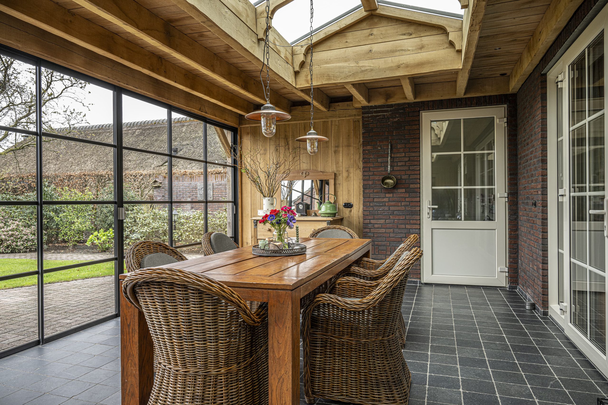 Interieur van een eikenhouten bijgebouw waarbij de lichtstraat in het dak zorgt voor optimale lichtinval op de tegelvloer.