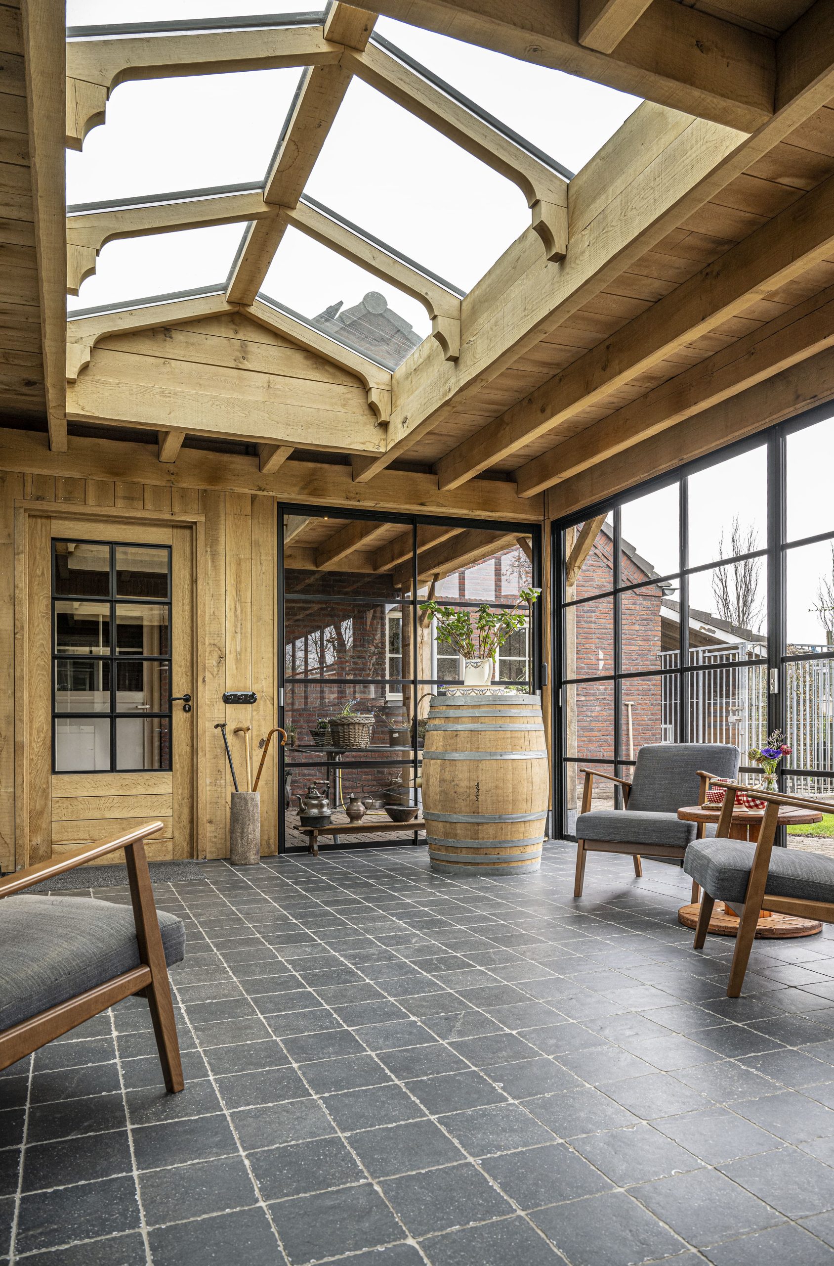 Een overzichtsfoto van het interieur van de overkapping waar het zonlicht door de lichtstraat op de antracietkleurige tegelvloer valt.