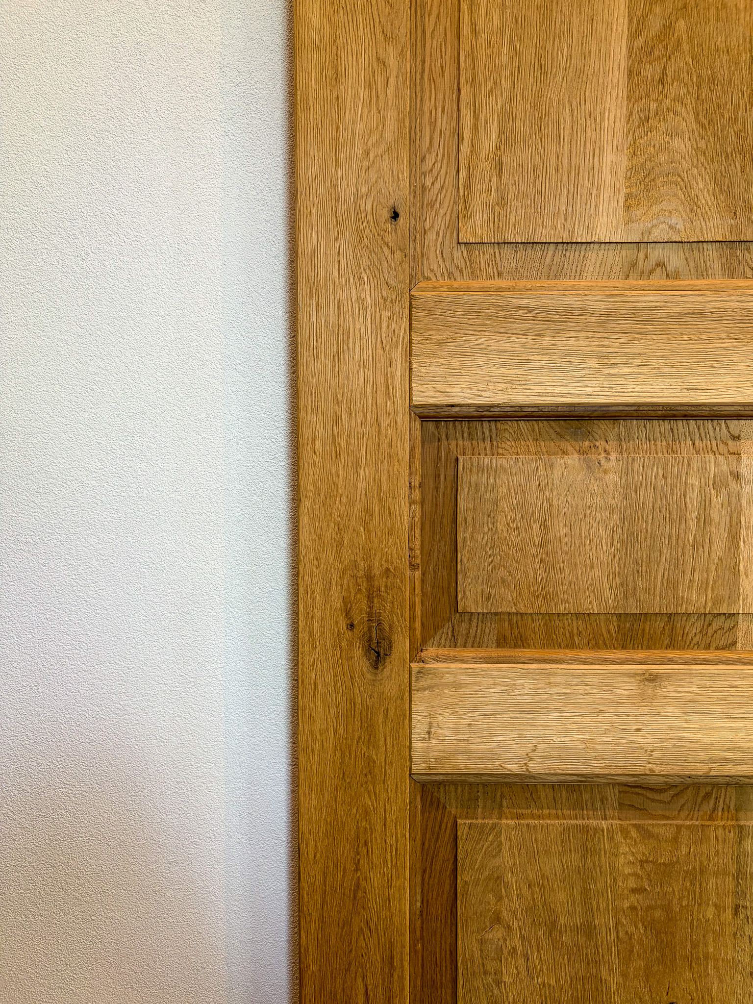 Close-up van de constructie van een eikenhouten deurpaneel, met focus op de verbindingen en de natuurlijke houtnerf.