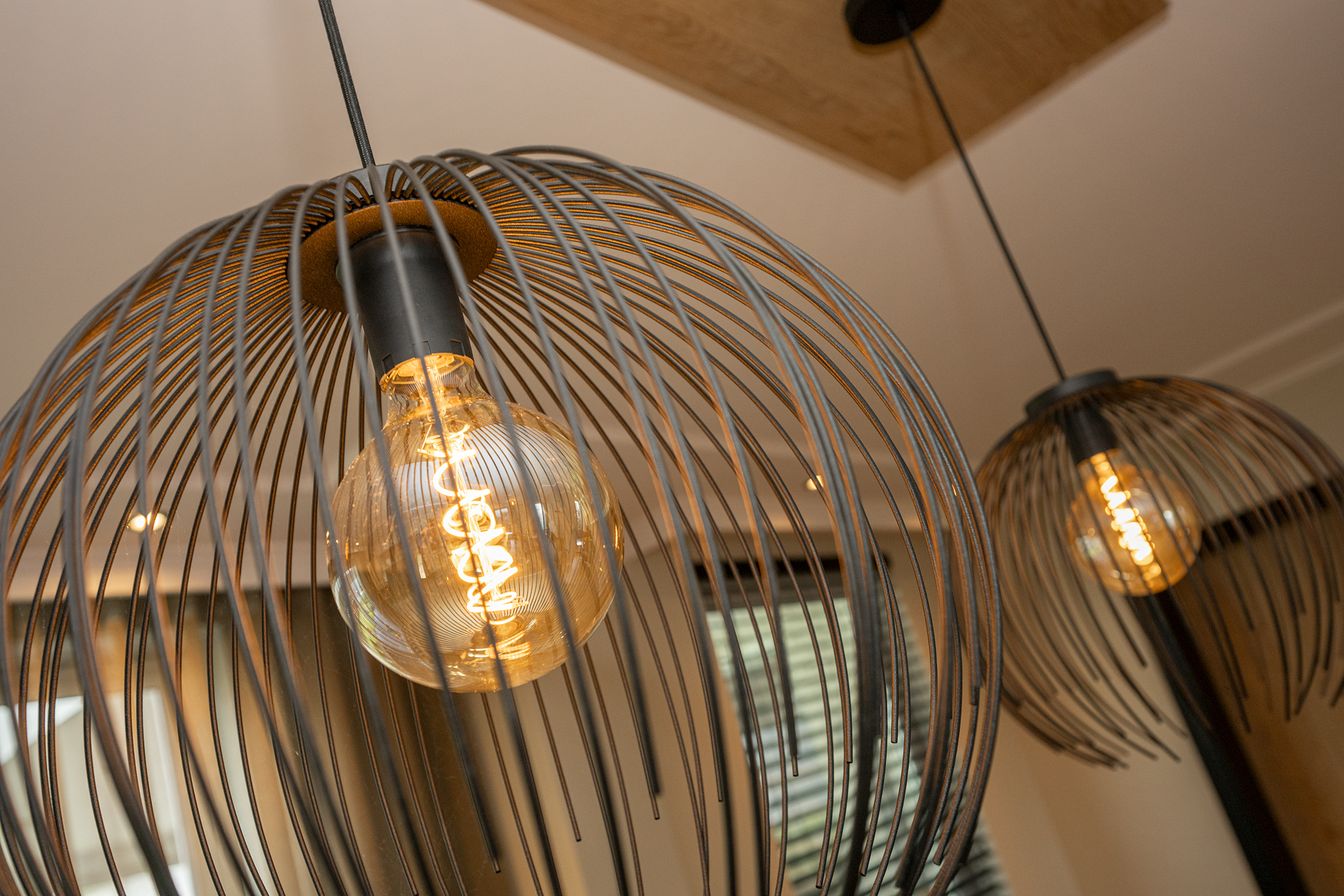 Close-up van twee industriële zwarte draadlampen met sfeervolle, brandende kooldraadlampen.