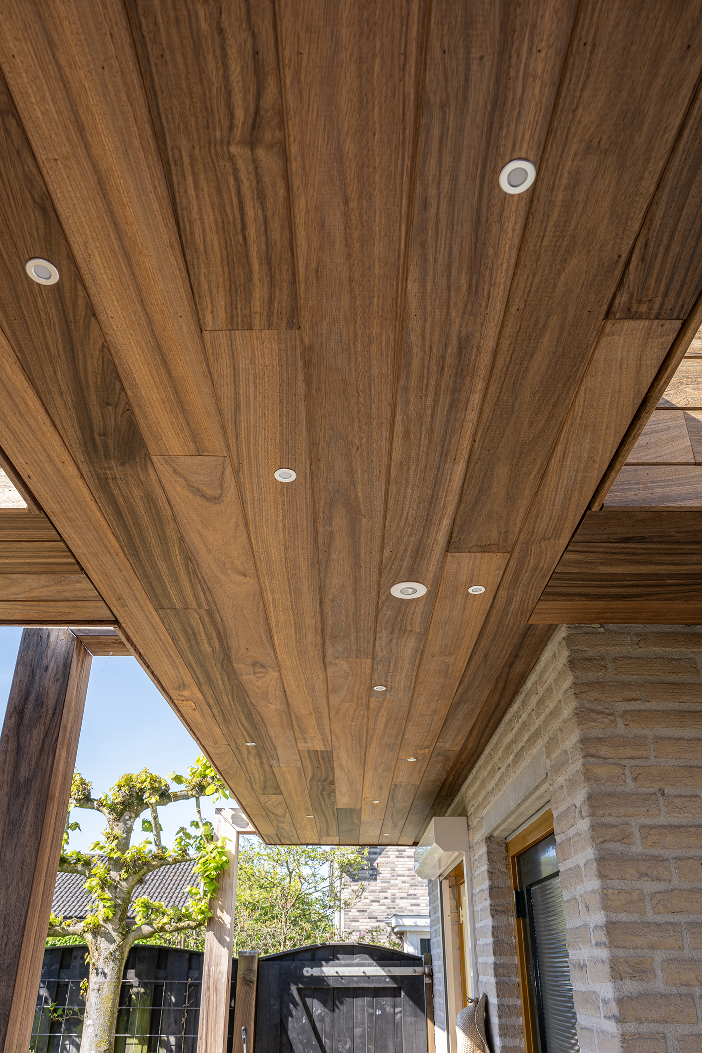 Onderaanzicht van de lange padoek houten planken met symmetrisch geplaatste led-spots.