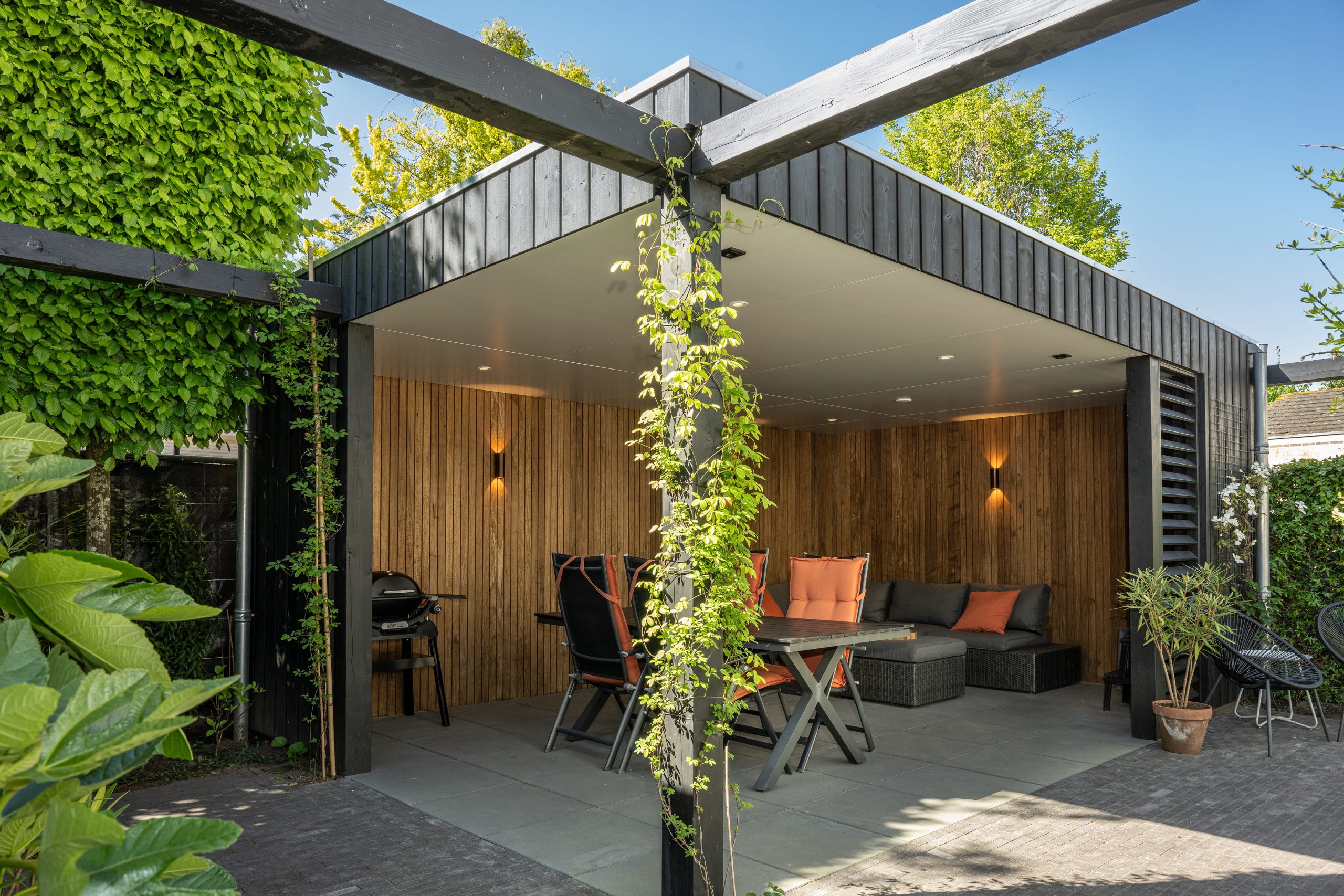 Moderne overkapping met thermo fraké wandbekleding en zwarte thermo vuren constructie.